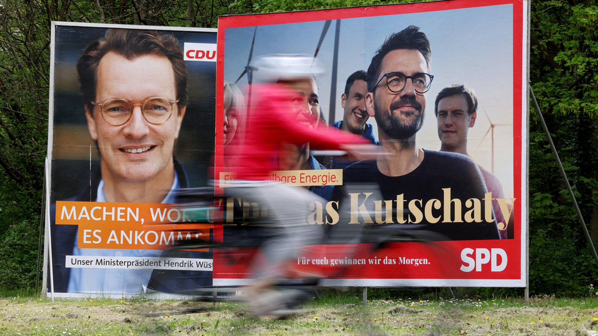 Köln: Wahlplakate mit Portraits der nordrhein-westfälischen Spitzenkandidaten von CDU, Wüst (l), und SPD, Kutschaty (r), stehen auf einer Wiese.