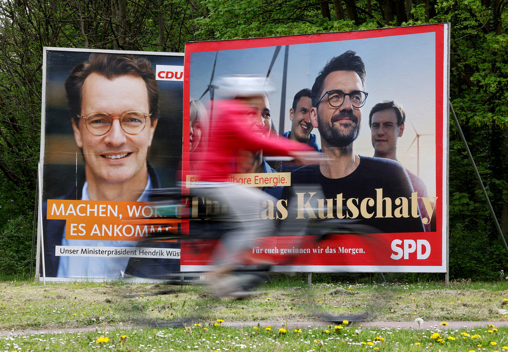 Köln: Wahlplakate mit Portraits der nordrhein-westfälischen Spitzenkandidaten von CDU, Wüst (l), und SPD, Kutschaty (r), stehen auf einer Wiese.
