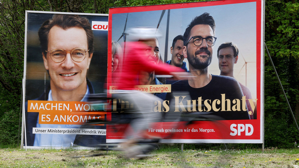 Köln: Wahlplakate mit Portraits der nordrhein-westfälischen Spitzenkandidaten von CDU, Wüst (l), und SPD, Kutschaty (r), stehen auf einer Wiese.