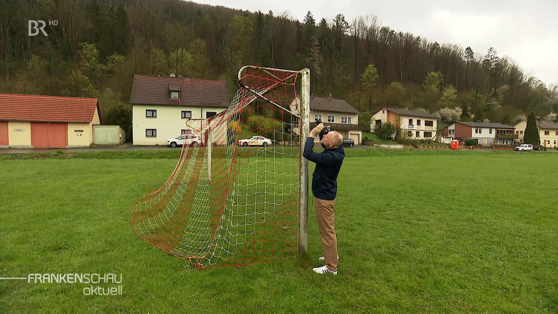Ein steht vor einem Mann Fußballtor und fotografiert es. 