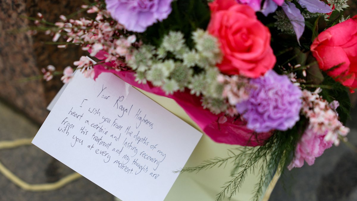 Blumen und eine Karte mit guten Wünschen für Kate liegen neben Windsor Castle 