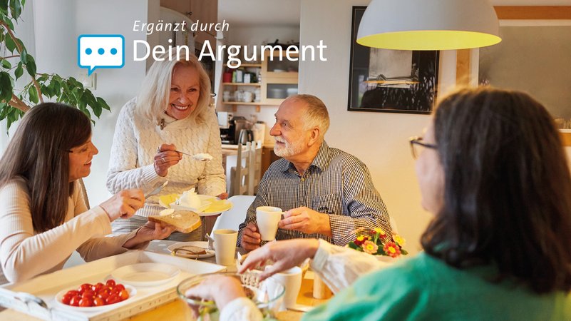 Senioren unterhalten sich und essen zusammen.