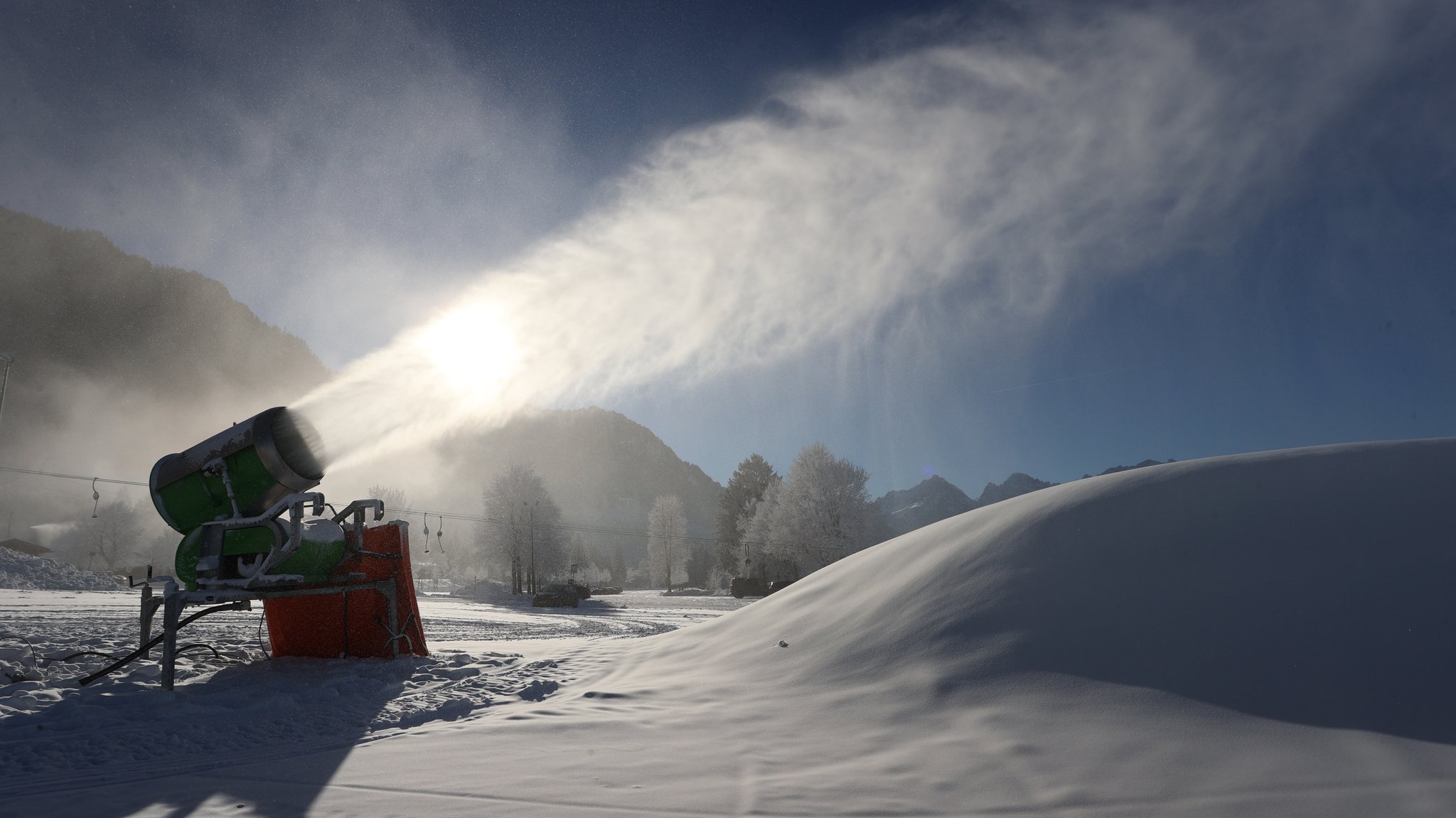 Symbolbild: Eine Schneekanone produziert an einer Skipiste Schnee.