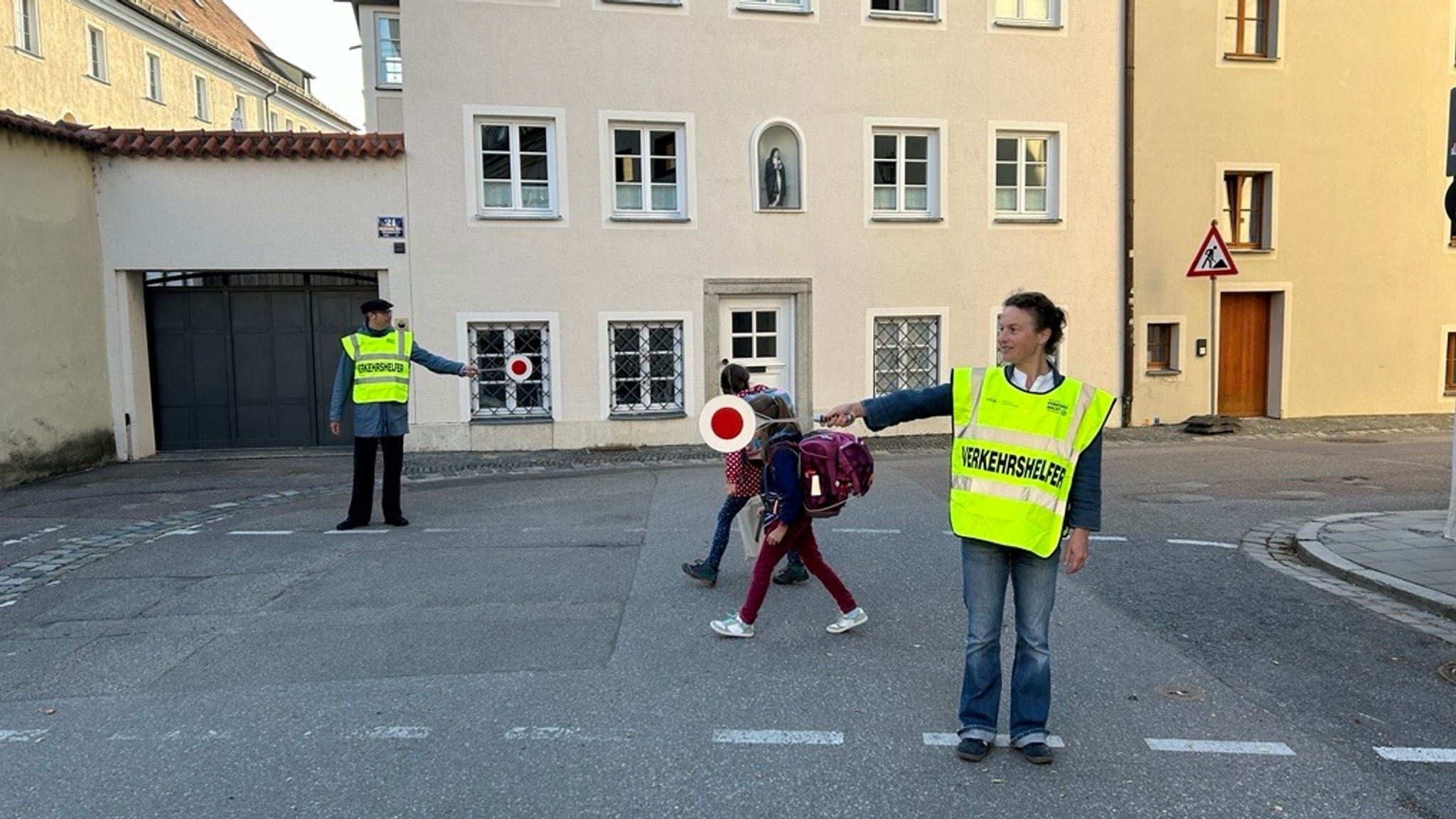 Vor der Gerhardinger Grundschule Regensburg werden Schülerinnen über die Straße geleitet. 