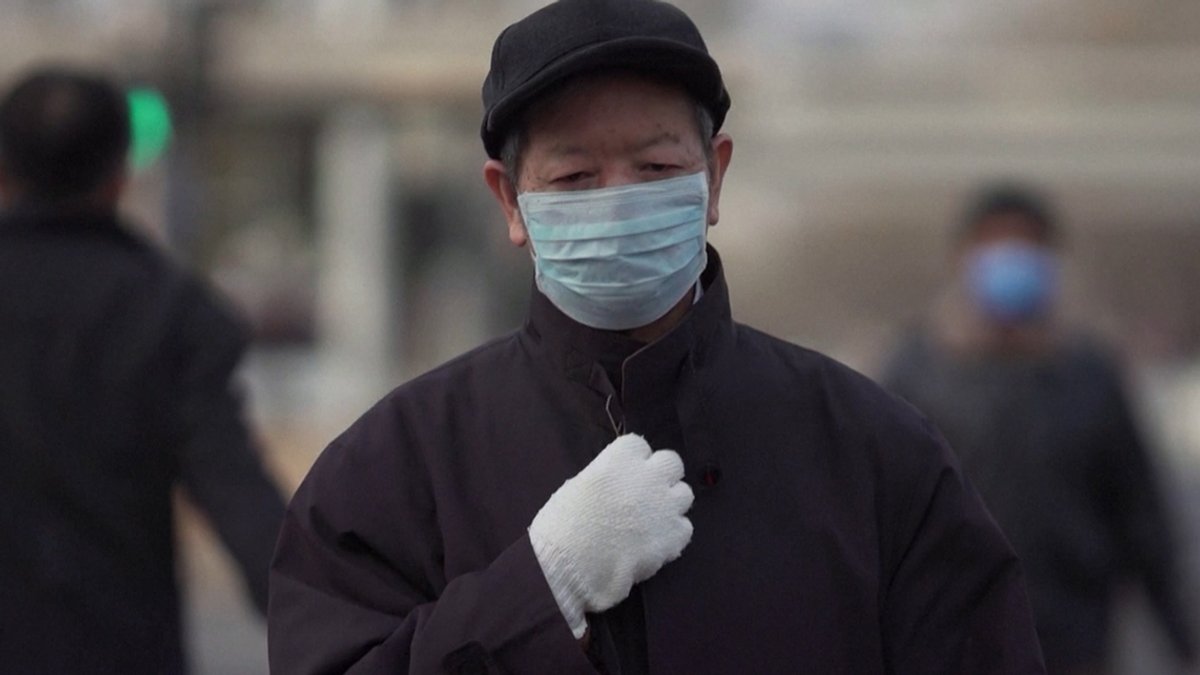 Chinese mit Mundschutz und Handschuhen