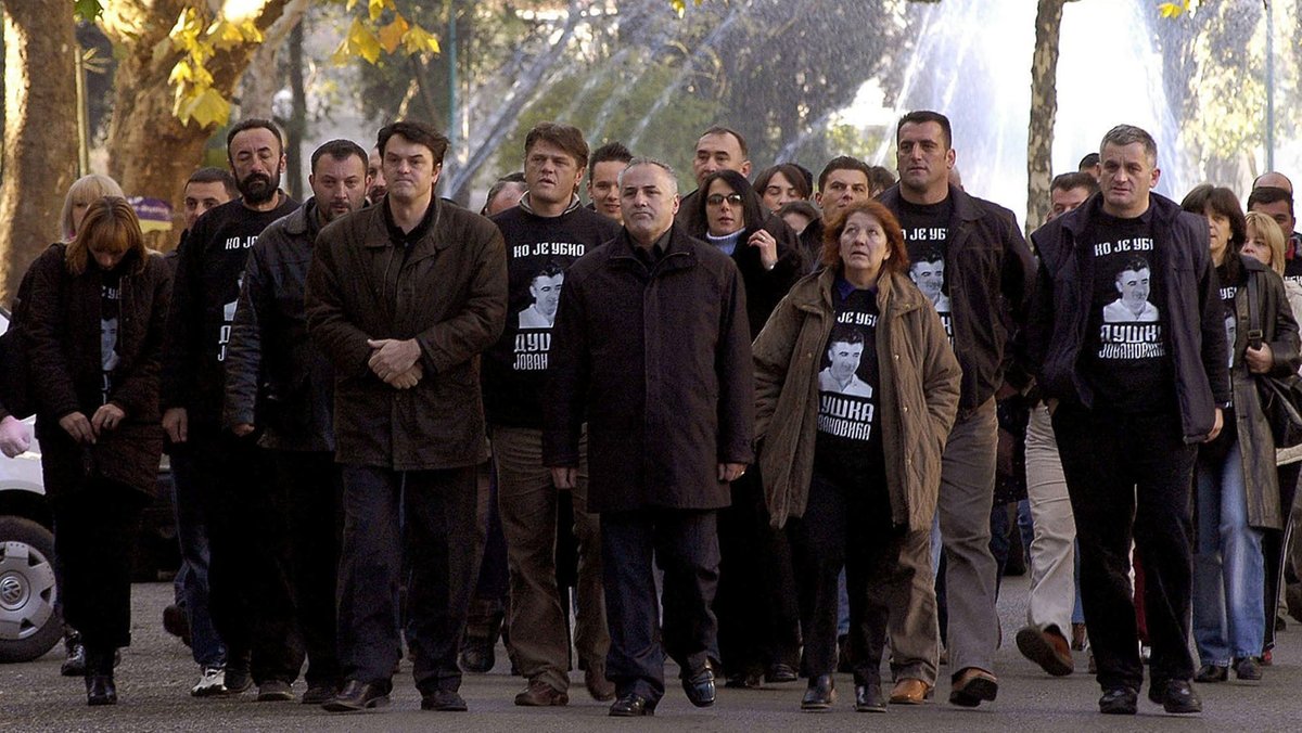 Eine Gruppe Protestierender trägt schwarze T-Shirts mit Aufschrift