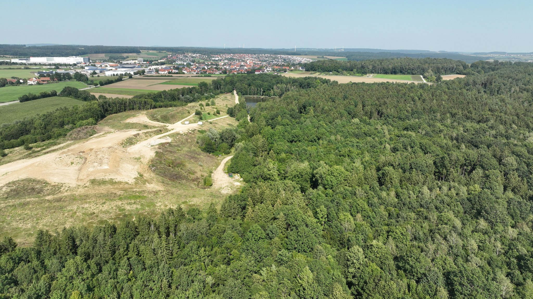 Blick auf die bestehende Deponie und den Wald daneben, der für die Erweiterung abgeholzt werden könnte.