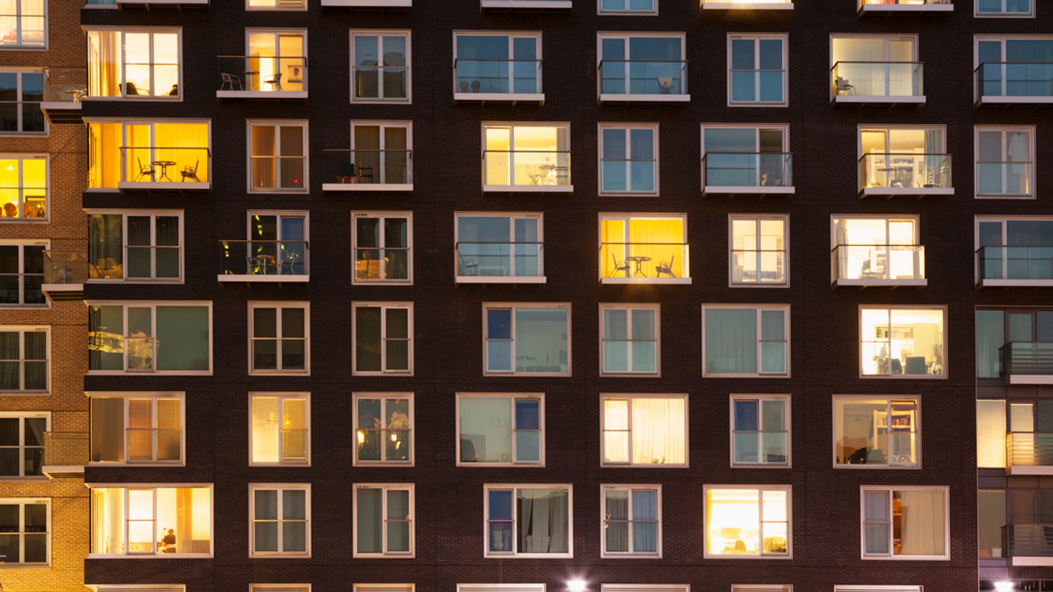 Erleuchtete Fenster in einem Mehrfamilienhaus.