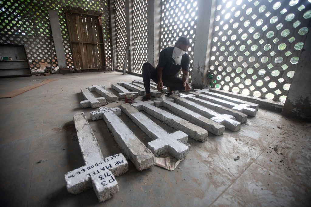 Ein Friedhofsmitarbeiter bereitet in Neu-Delhi, Indien, frische Markierungen für die Gräber von Covid-19-Toten vor. In Indien sind die Infektionen zuletzt stark gestiegen.