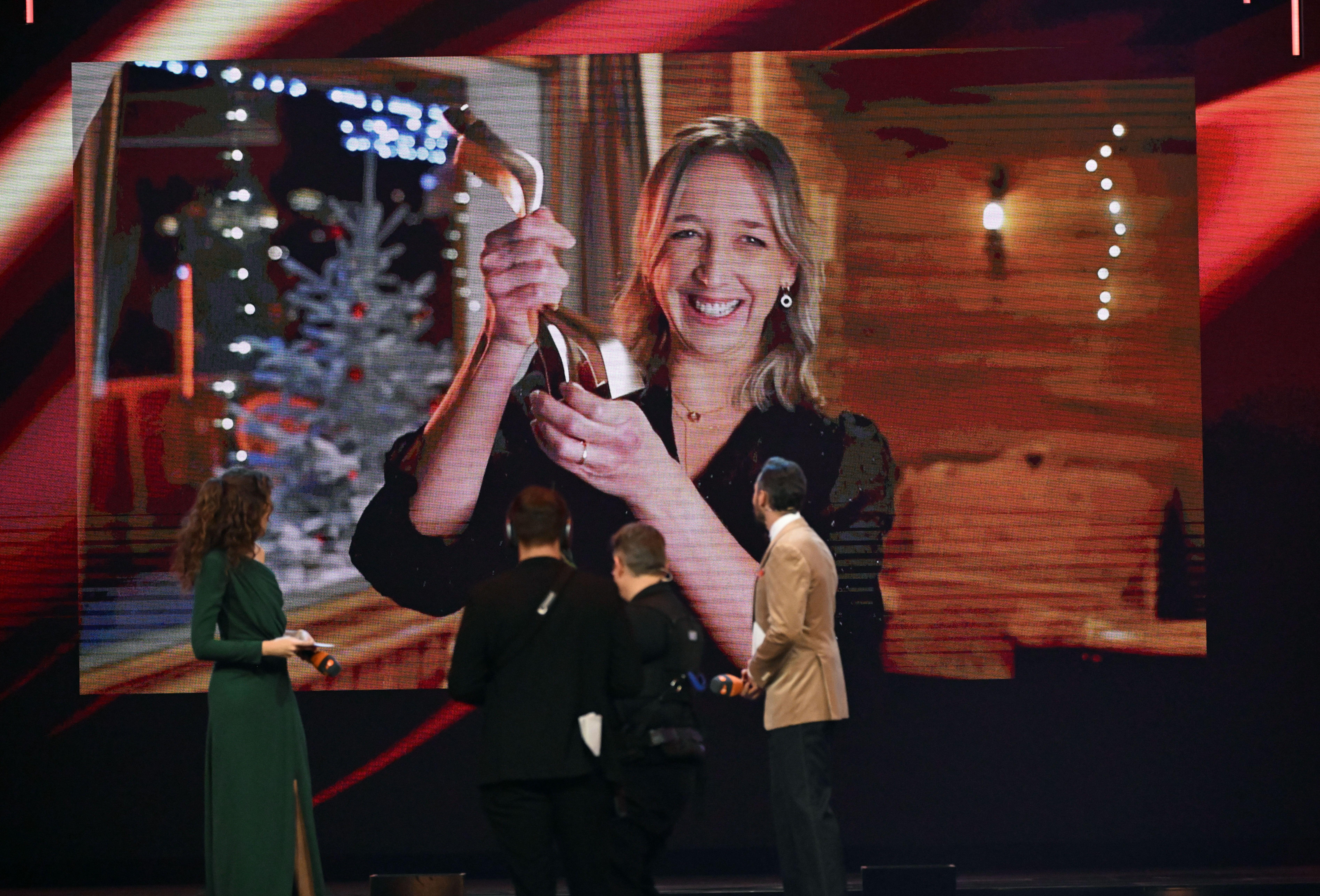 Auf dem Bild ist eine Leinwand zu sehen auf der die Biathletin Franziska Preuß ihre Trophäe als Sportlerin des Jahres in die Kamera hält