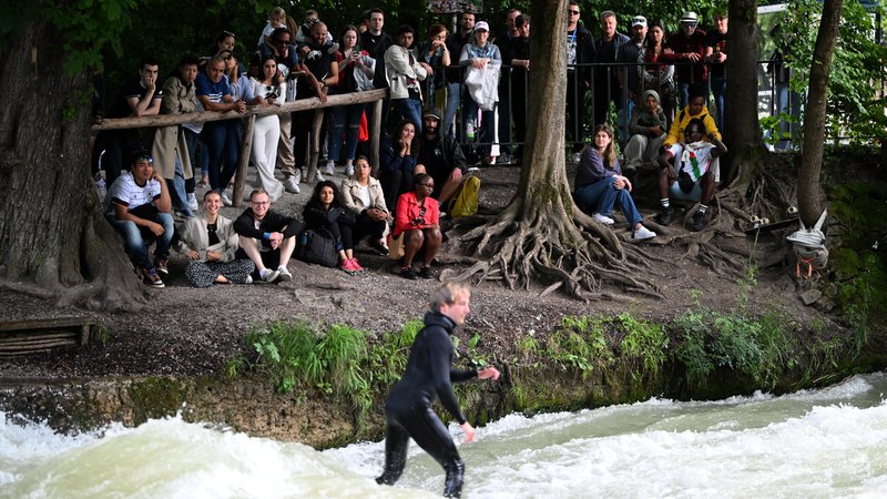 Blick auf den Münchner Eisbach und Zuschauer am Ufer. | Bild: picture alliance / Anadolu | Gokhan Balci Blick auf den Münchner Eisbach und Zuschauer am Ufer.