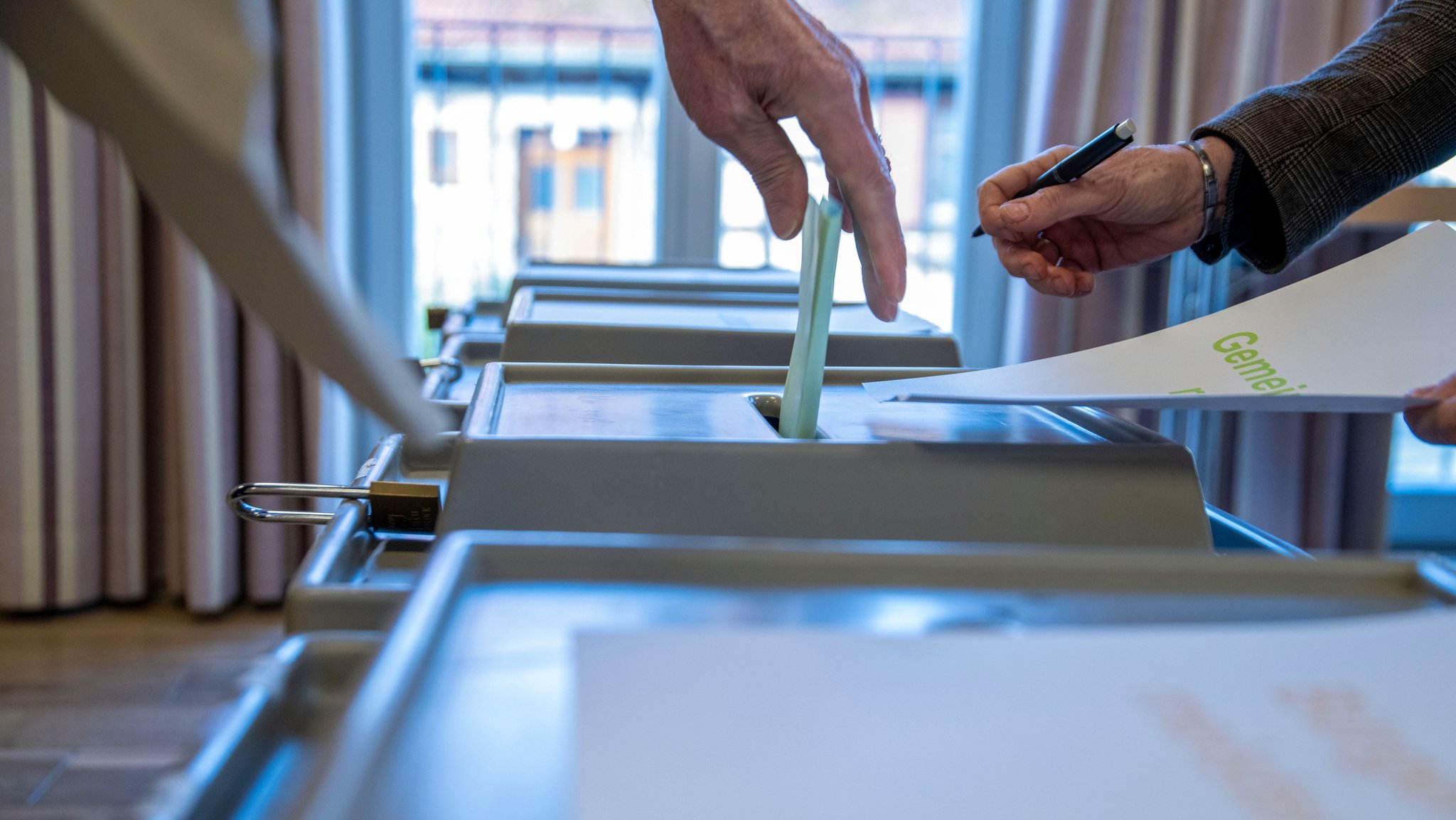 Ein Mann wirft einen ausgefüllten Wahlzettel in eine Wahlurne. (Symbolbild)
