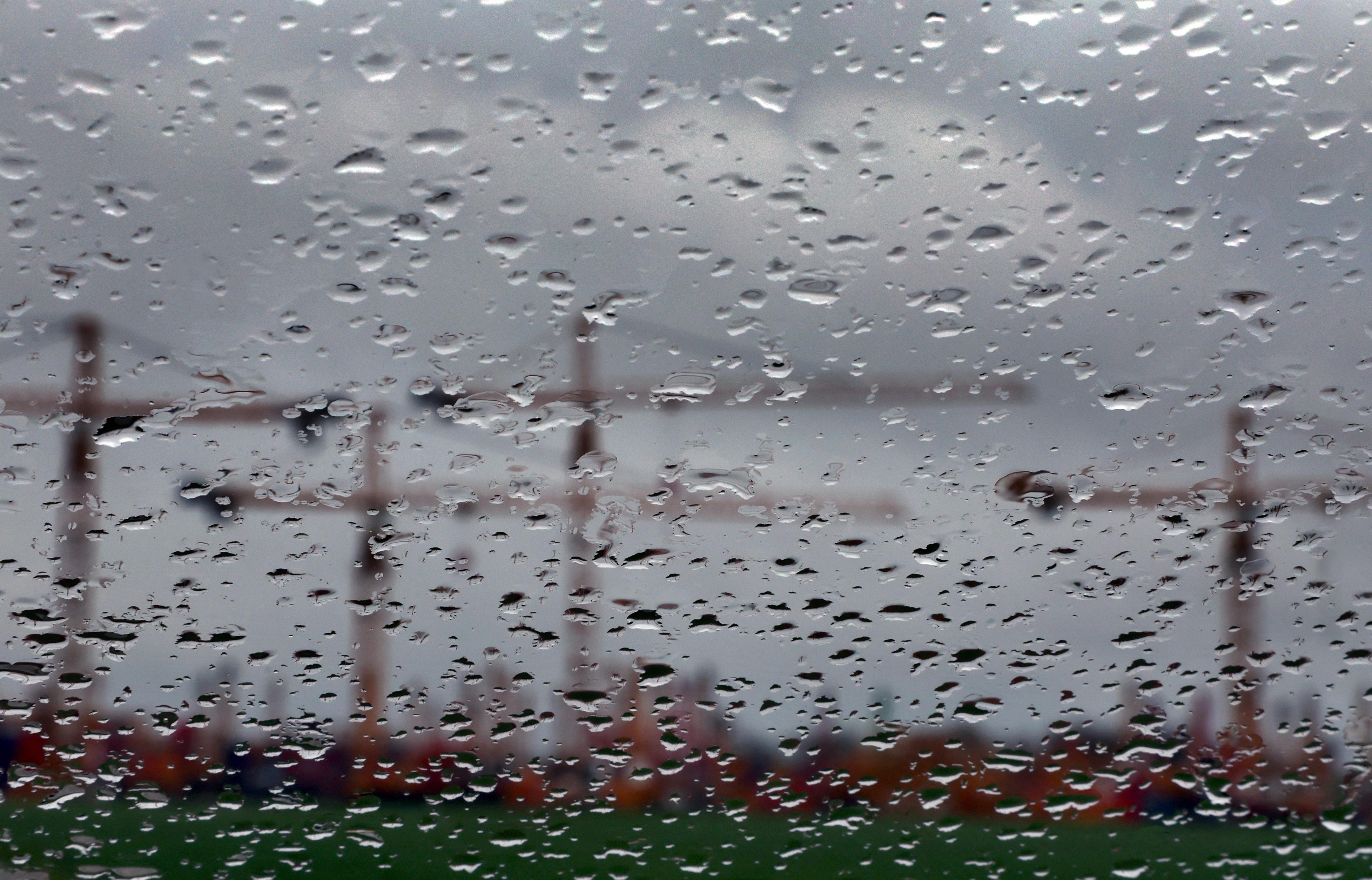 Trübe Konjunkturaussichten:  Bayern, Mindelheim: Hinter einer regennassen Scheibe sind Baukräne auf dem Gelände eines Kranservice unter dichten Wolken zu sehen.