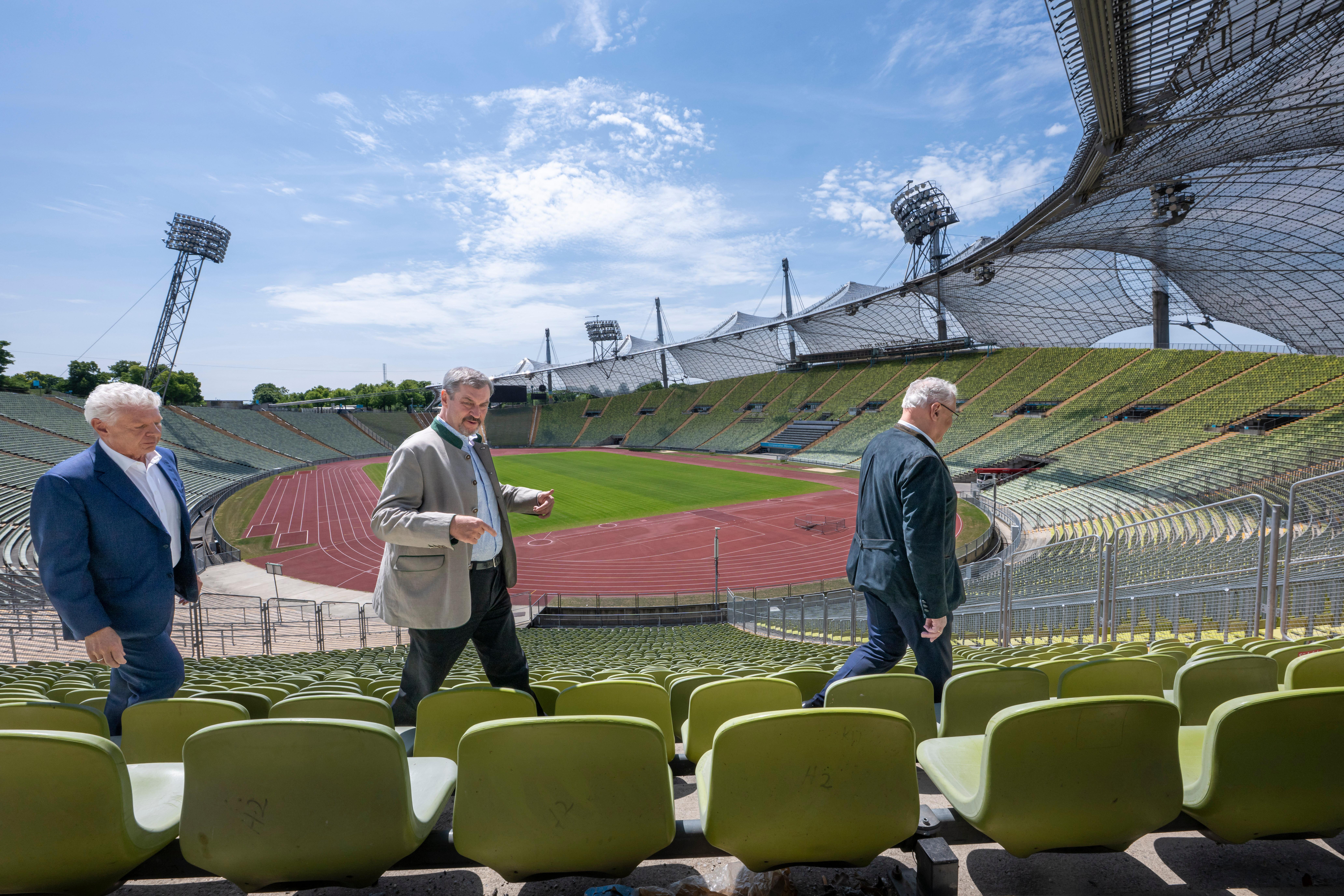 Archivbild: Dieter Reiter (l-r,SPD), Oberbürgermeister von München, Markus Söder (CSU), Ministerpräsident von Bayern, und Joachim Herrmann (CSU), Staatsminister des Innern, für Sport und Integration, stehen nach der Sitzung des bayerischen Kabinetts im Zuschauerbereich des Olympiastadion.