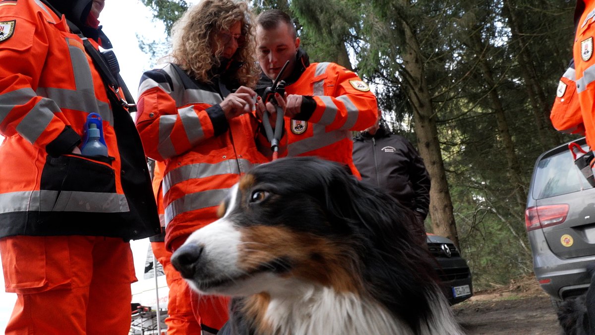 Mitglieder der Rettungshundestaffel Zwiesel im Bayerischen Wald mit Hund hantieren mit einem Funkgerät