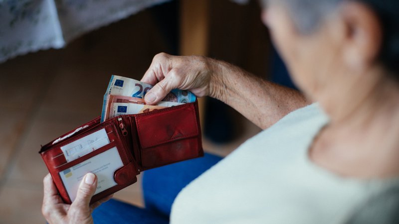 Eine Seniorin mit einem Geldbeutel in der Hand. | Bild: BR/Julia Müller Eine Seniorin mit einem Geldbeutel in der Hand.