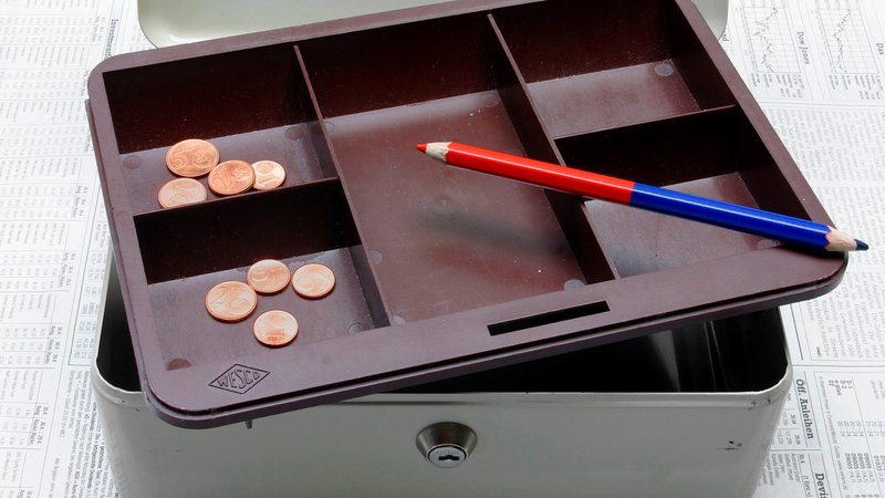 Eine leere Kasse, in der nur noch ein paar Cent-Münzen liegen. Auch ein Rotstift liegt darin. | Bild: picture alliance / imageBROKER | Jürgen Eis Eine leere Kasse, in der nur noch ein paar Cent-Münzen liegen. Auch ein Rotstift liegt darin.
