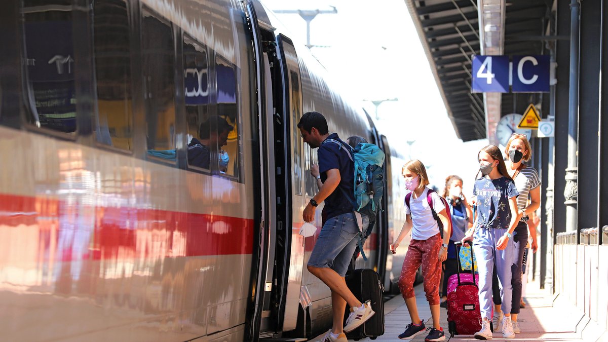 Ein Familie steigt mit Rucksack und Koffern in einen ICE ein