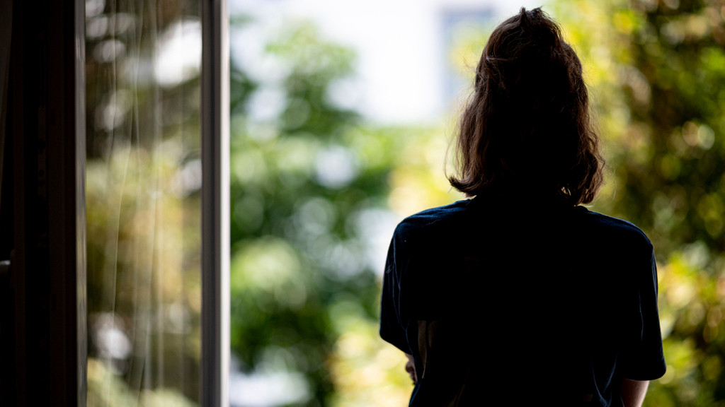 "Nach Corona ist vor der Therapie" - ARCHIV - 13.07.2021, Berlin: Eine Frau steht in ihrer Wohnung an einem Fenster. Baden-Württemberg verzeichnet nach Angaben der Krankenkasse DAK einen landesweiten Rekord an Arbeitsausfällen durch psychische Erkrankungen 