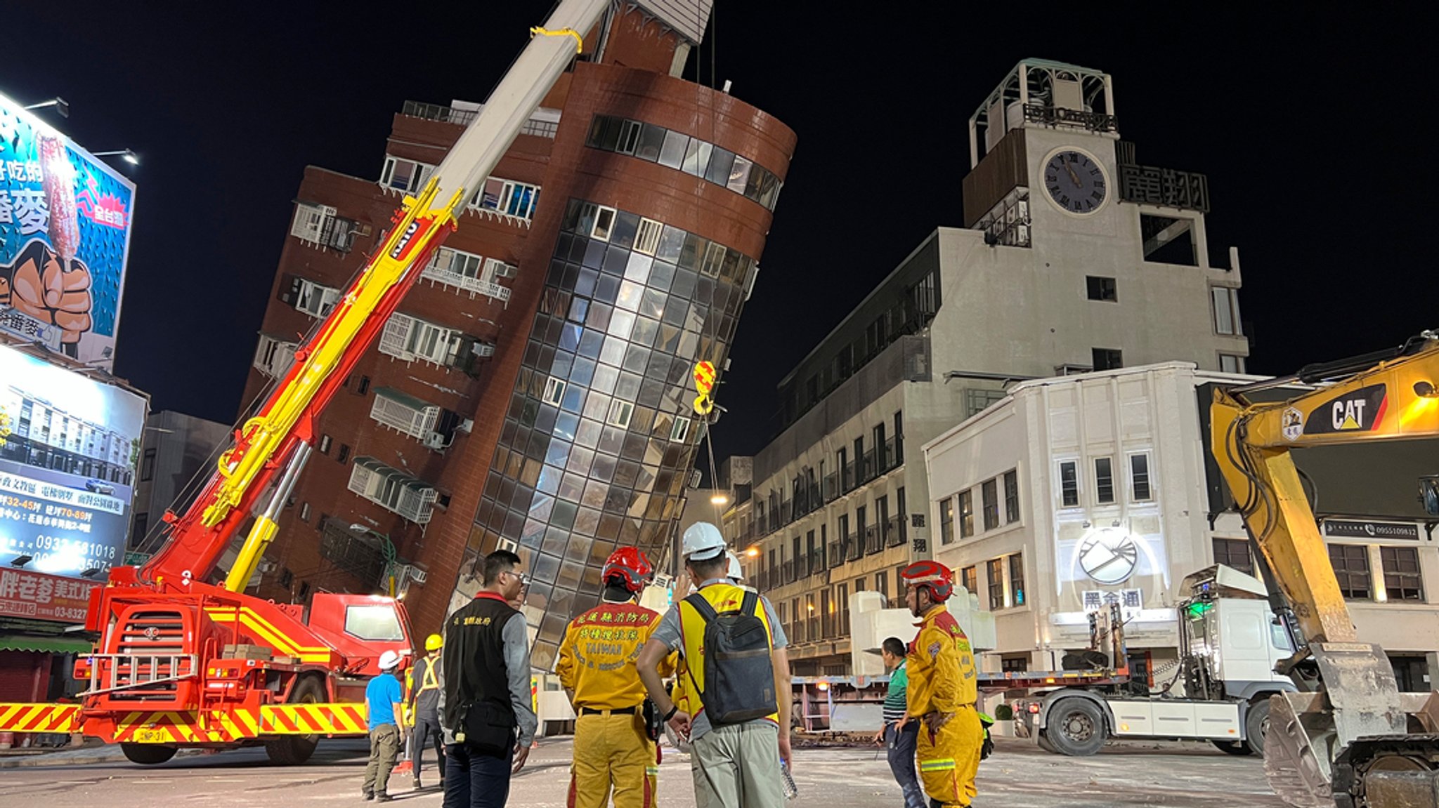 Rettungskräfte stehen nach einem Erdbeben in Hualien im Osten Taiwans in der Nähe eines schiefen Gebäudes. 