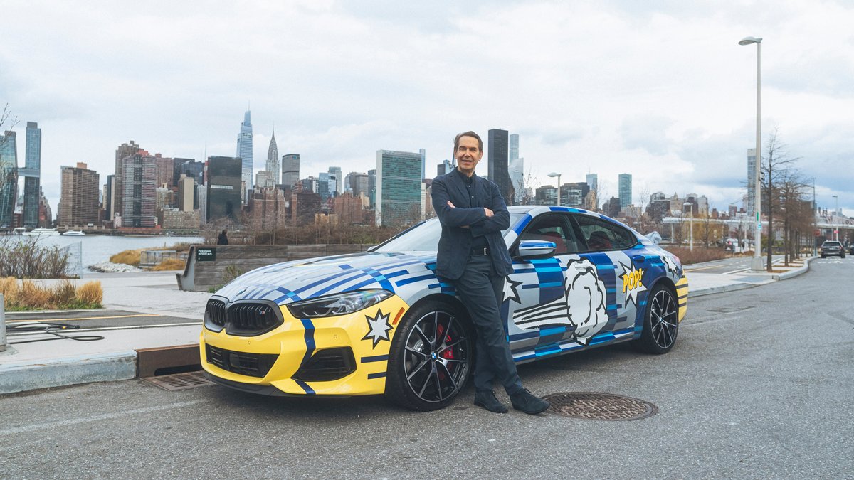 Der Künstler Jeff Koons steht vor seinem selbst designten BMW.