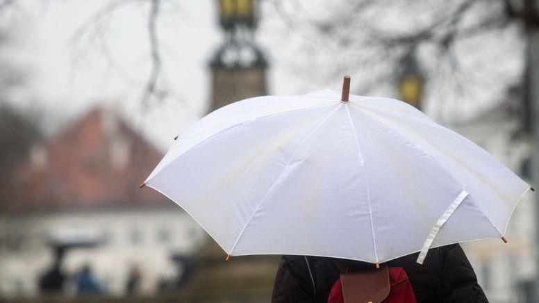 Eine Frau geht mit Regenschirm am Schlosskanal Nymphenburg entlang. | Bild:dpa-Bildfunk/Stefan Puchner