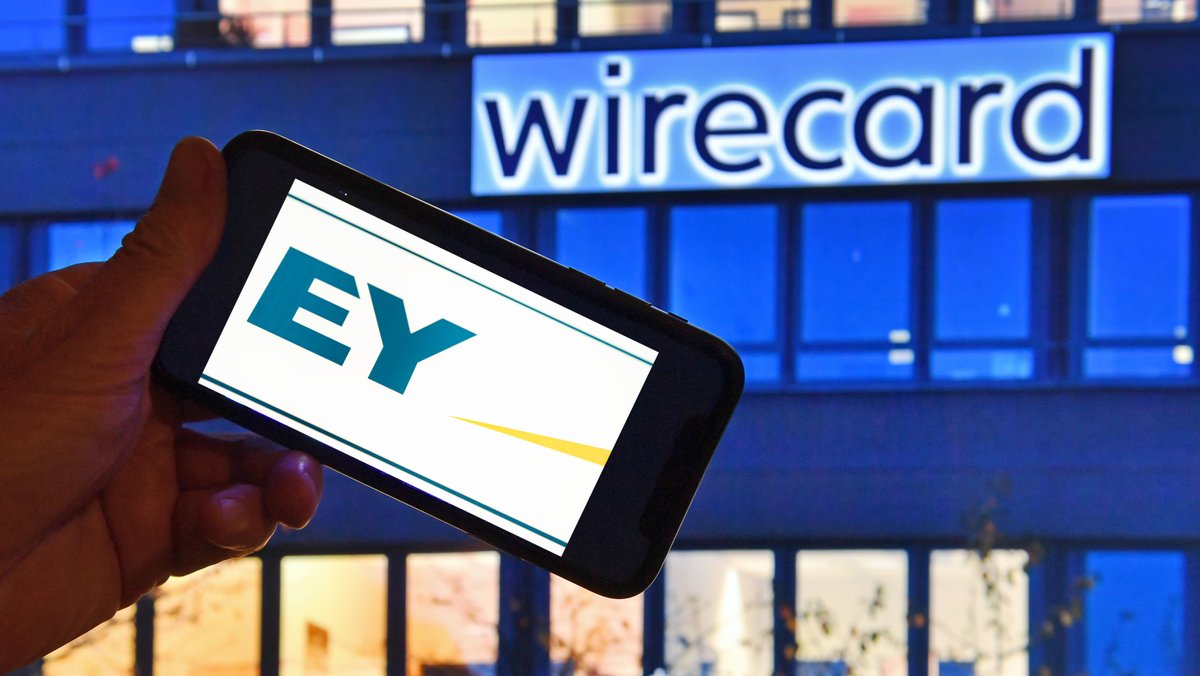 EY-Logo auf einem Smartphonebildschirm vor einem Gebäude mit dem Schriftzug Wirecard