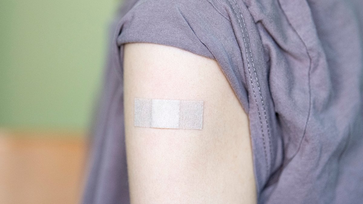 Auf dem Arm einer Jugendlichen klebt ein Pflaster, nachdem sie bei einem Kinder- und Jugendarzt mit dem Corona-Impfstoff Comirnaty von Biontech/Pfizer geimpft wurde.