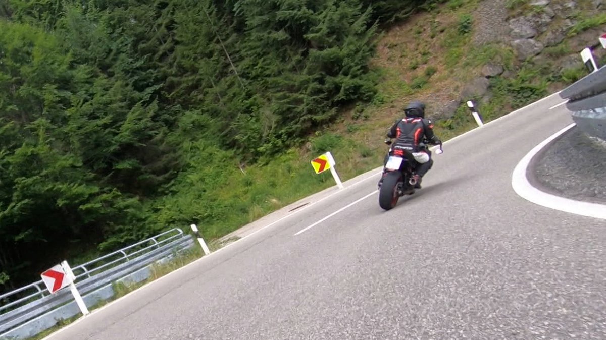 Ein Motorradfahrer am Riedbergpass fährt in Schräglage in einer Kurve