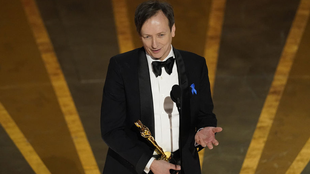 Volker Bertelmann nimmt den Preis für die beste Filmmusik für «Im Westen nichts Neues» bei der Oscar-Verleihung im Dolby Theatre in Los Angeles entgegen. Foto: Chris Pizzello/Invision/AP +++ dpa-Bildfunk +++