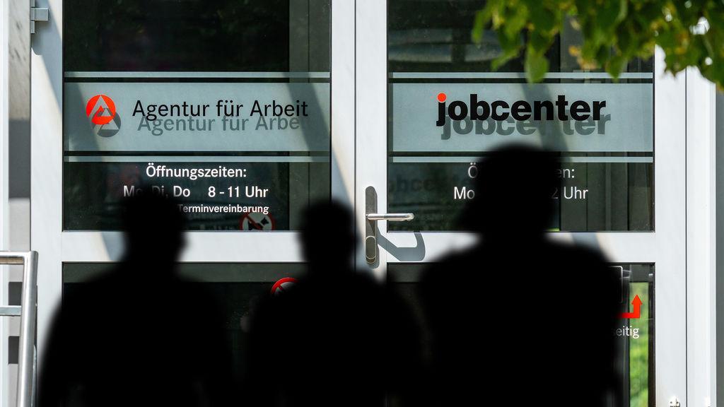 Menschen vor der Agentur für Arbeit und dem Jobcenter.