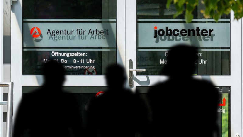 Menschen vor der Agentur für Arbeit und dem Jobcenter. | Bild: dpa-Bildfunk/Michael Bihlmayer Menschen vor der Agentur für Arbeit und dem Jobcenter.