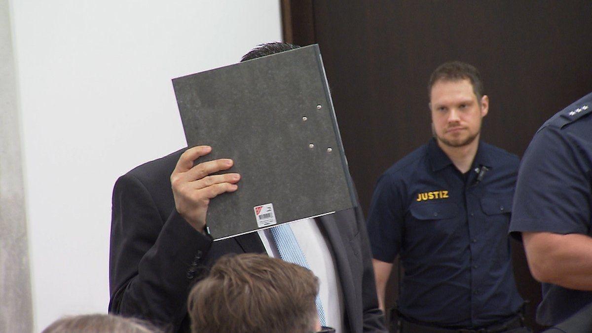 Der Angeklagte Dejan B., Ex-Partner von Alexandra R., mit einem Ordner vor dem Gesicht im Gerichtssaal.