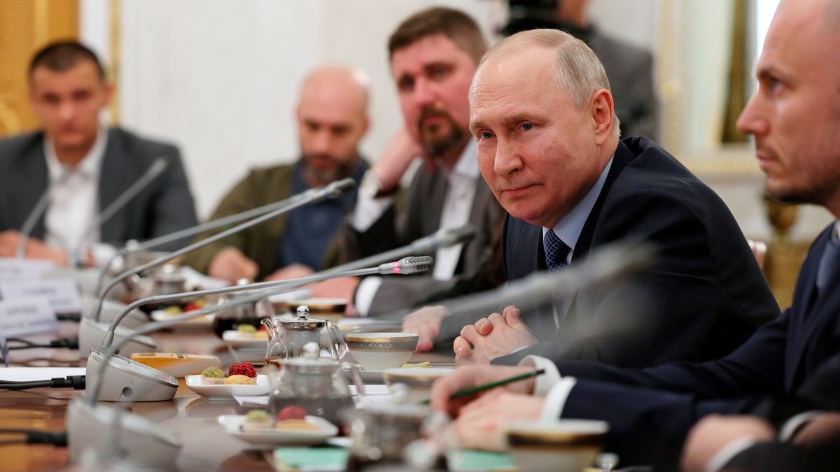 Der russische Präsident am Konferenztisch mit Mikrofonen