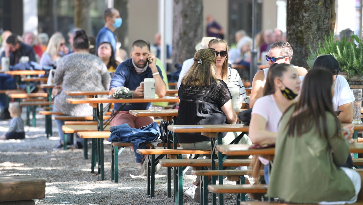 Menschen sitze in München in einem Biergarten