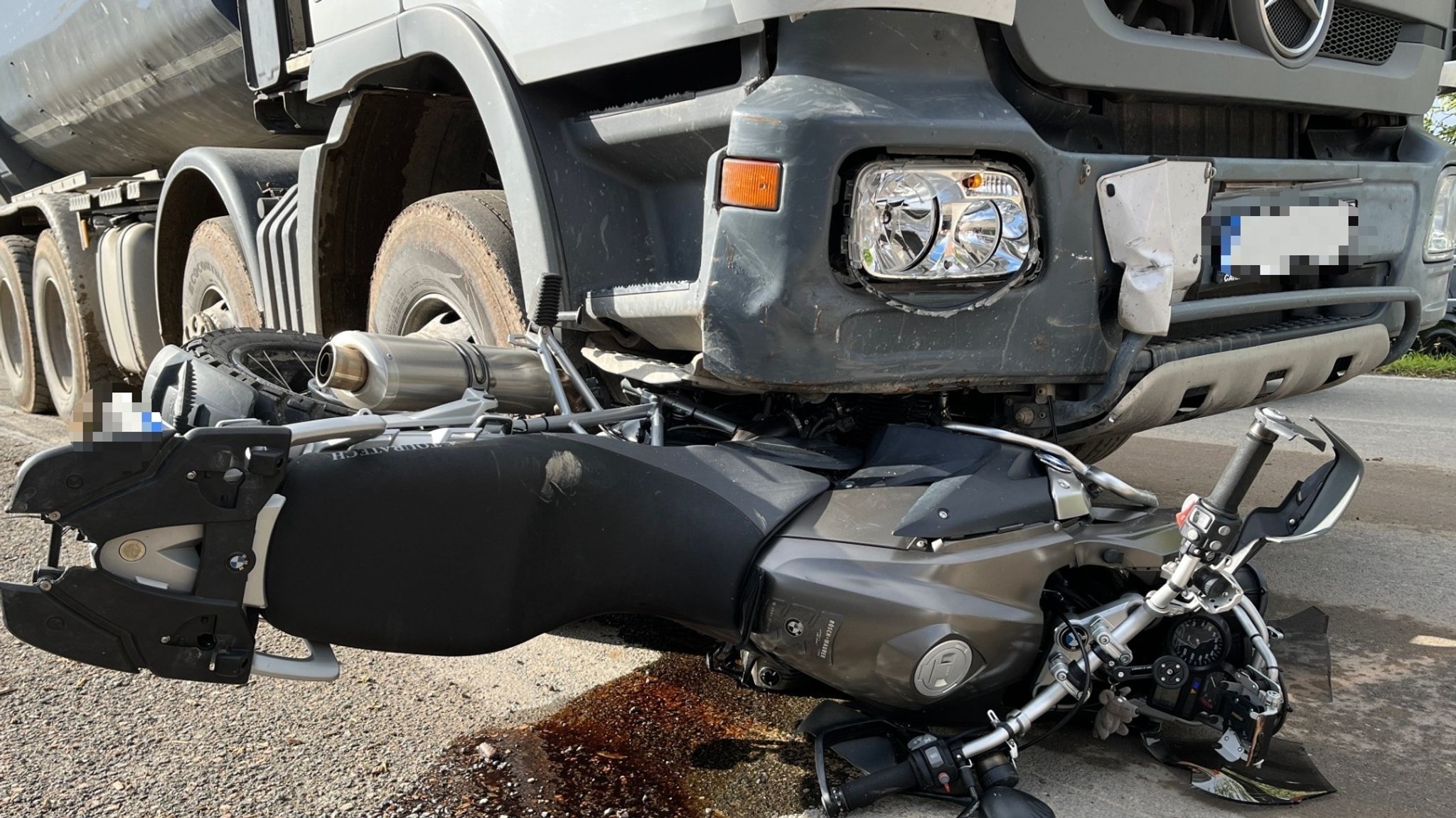 Ein Motorrad liegt vor einem Lkw.