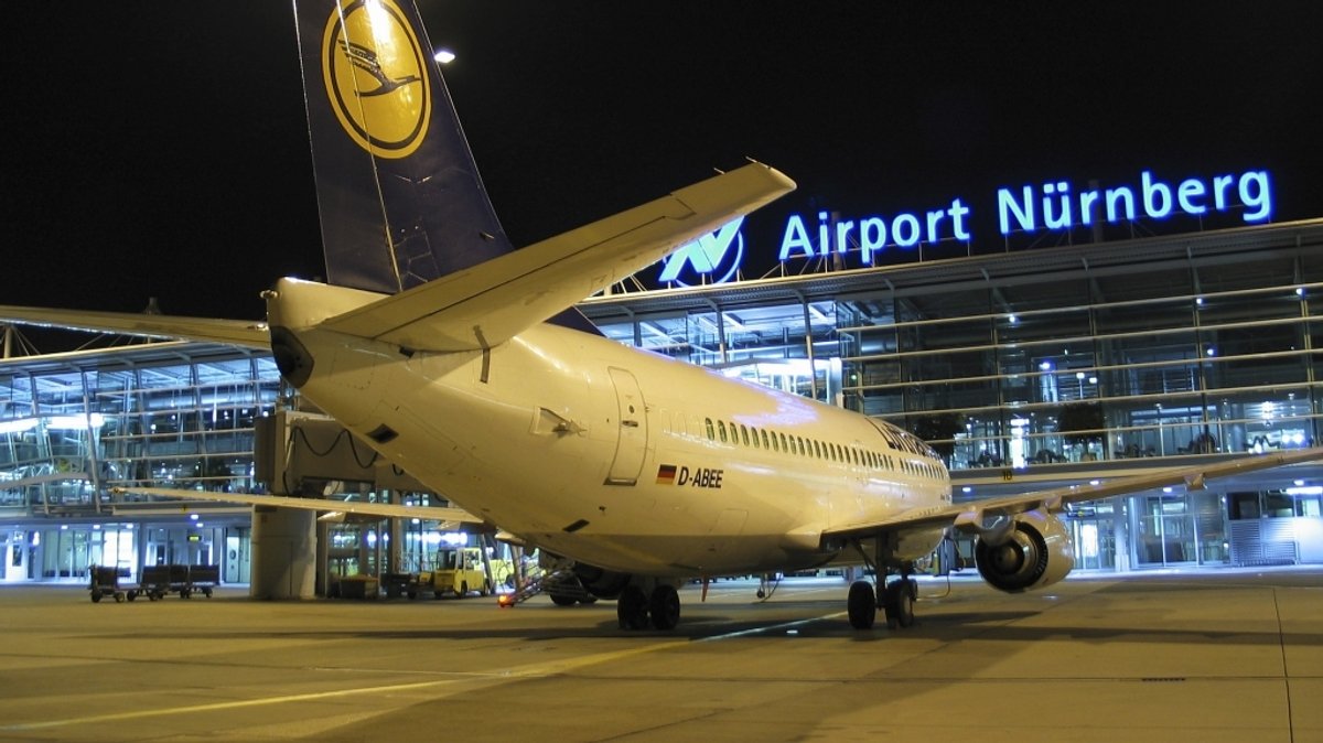 Ein Flugzeug steht bei Nacht vor dem Airport Nürnberg