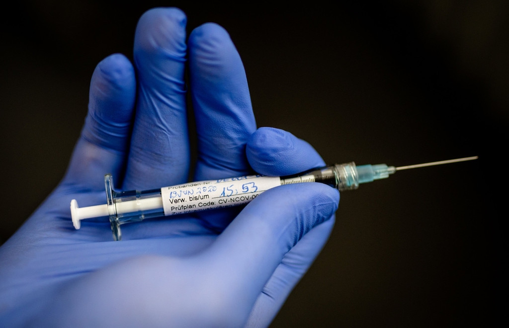 Person hält Impfspritze der Curevac Impfstoff-Studie in den Händen