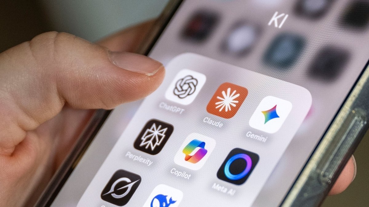 Auf einem Smartphone-Bildschirm sind mehrere KI-Anwendungen zu sehen, darunter ChatGPT, Claude, Gemini, Perplexity, Microsoft Copilot, Meta AI, Grok und DeepSeek