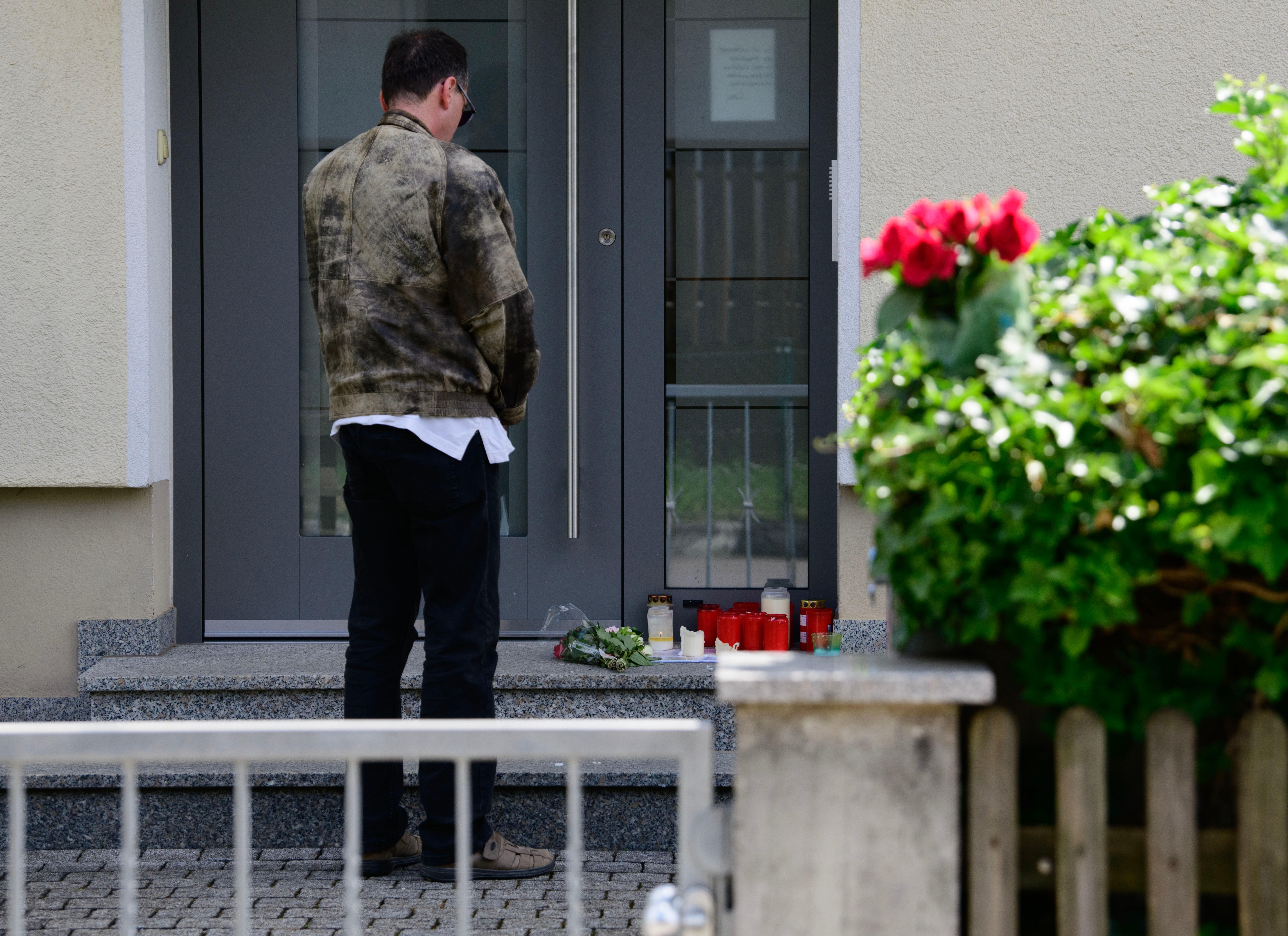 Ein Mann steht vor dem Eingang des Hauses, in dem ein 64-Jähriger drei Menschen erschossen haben soll.