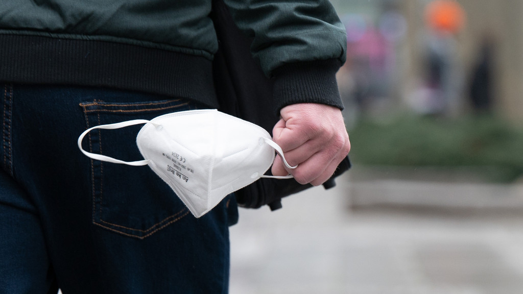 Mann hält FFP2-Maske in der Hand
