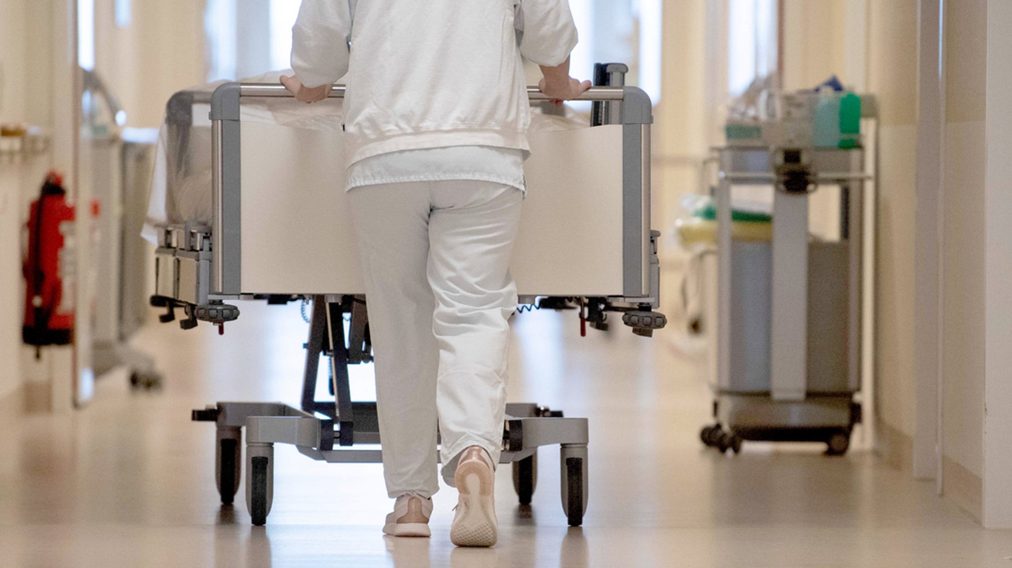 Eine Krankenpflegerin schiebt ein Krankenbett durch einen Krankenhausflur. | Bild: dpa-Bildfunk/Marijan Murat Eine Krankenpflegerin schiebt ein Krankenbett durch einen Krankenhausflur.