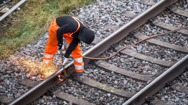 Symbolbild Langsamfahrstellen in Bayern ARCHIV - 11.12.2023, Bayern, Forchheim: Ein Arbeiter zerteilt ein altes Bahngleis an der Bahnbaustelle der ICE-Strecke zwischen Nürnberg und Bamberg. | Bild: dpa-Bildfunk/Daniel Vogl Symbolbild Langsamfahrstellen in Bayern ARCHIV - 11.12.2023, Bayern, Forchheim: Ein Arbeiter zerteilt ein altes Bahngleis an der Bahnbaustelle der ICE-Strecke zwischen Nürnberg und Bamberg.