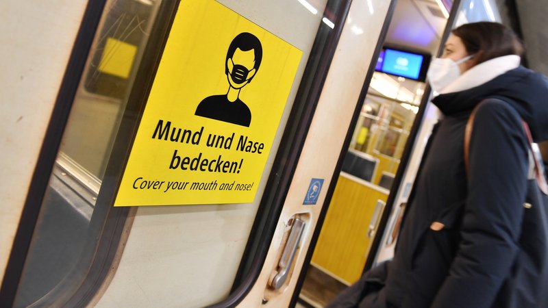 Eine Frau steigt mit FFP2-Maske in München in eine U-Bahn.