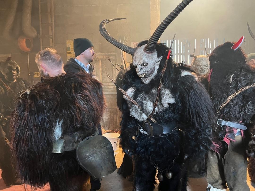 Menschen haben sich dunkle Felle und furchteinflößende Masken angezogen mit langen Hörnern