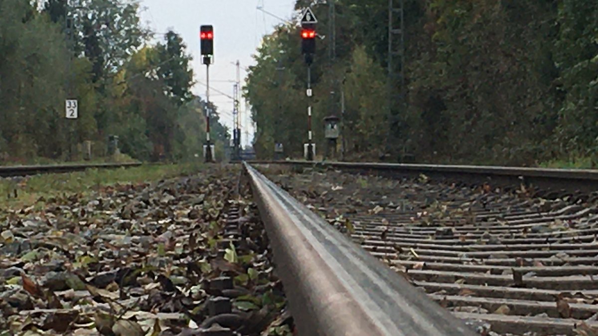 Bahngleis mit Schotter und zwei roten Gleisampeln  an der Bahnstrecke Holzkirchen - Rosenheim
