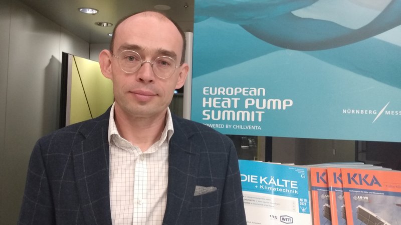 Marek Miara vor einem Schild des European Heat Pump Summit in der NürnbergMesse.