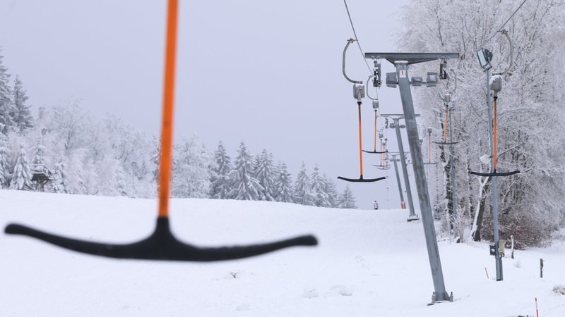 Leere Bügel hängen an einem Skilift. 