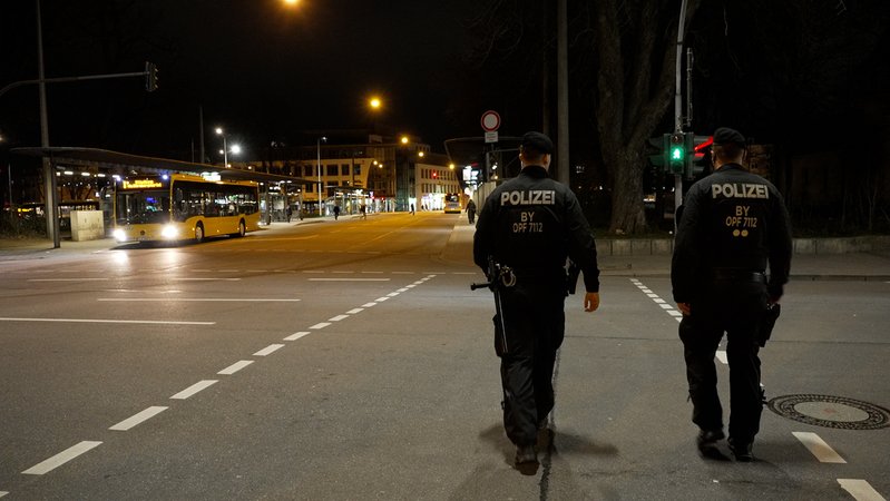 Zwei Polizisten in dunkler Kleidung auf einem Fußgängerüberweg