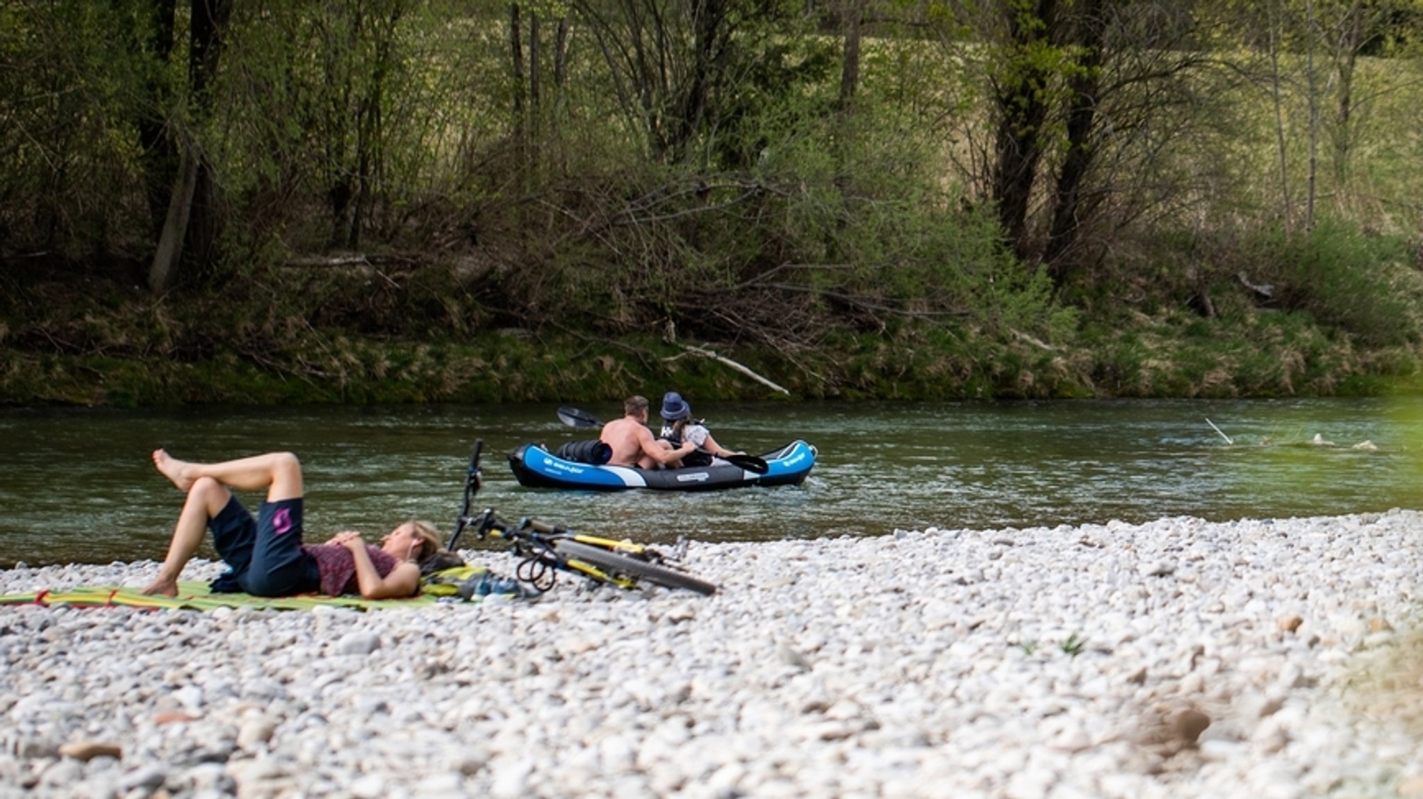 Ausflügler mit einem Boot auf der Isar.